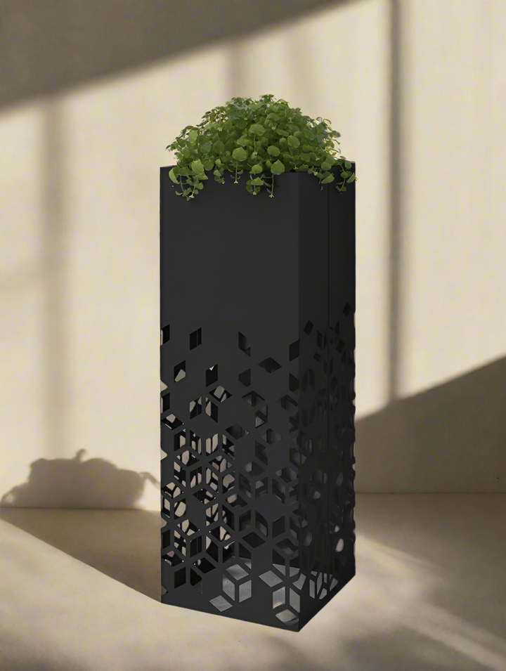 Black geometric patterned planter with green plant against a gray background