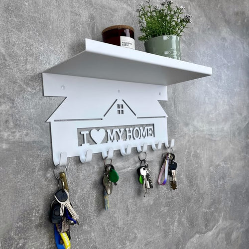 Key holder with 'I love my home' text on a gray wall.